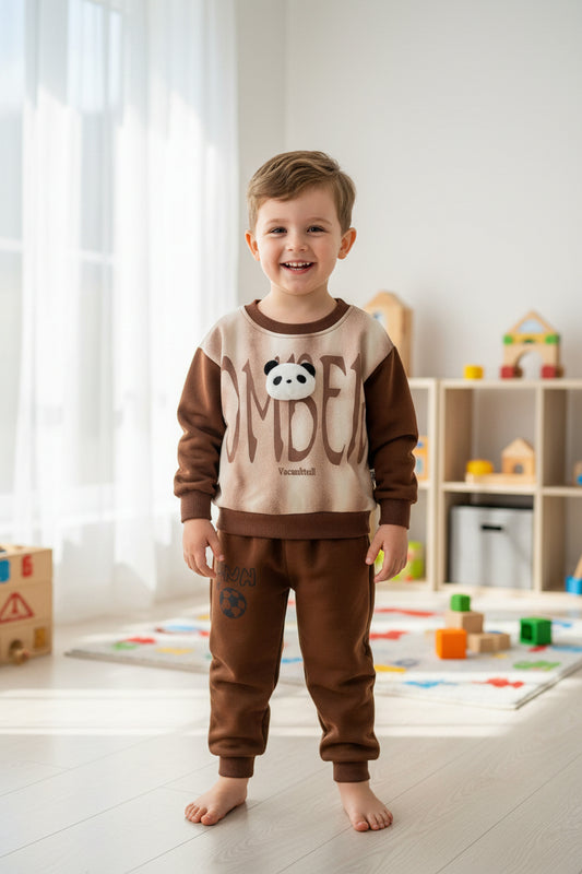 Children's brown and beige outfit with panda design on a wooden surface